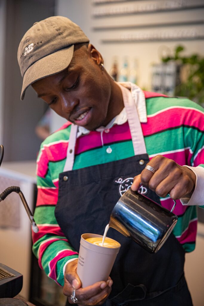 Justice making latte art at the coffee maschine.